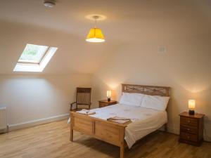 a bedroom with a bed with two night stands and a window at 17 Canons Lane in Clifden