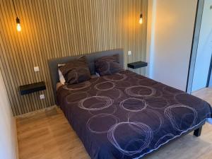 ein Schlafzimmer mit einem Bett mit einer lila Bettdecke in der Unterkunft Chambre d'hôtes NATURISTE Le Jardin Des Hirondelles in Blanzaguet-Saint-Cybard
