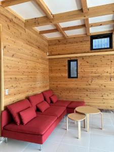 a red couch in a room with wooden walls at Kita Karuizawa Morino Takibi NO7 Sauna Sweet in Tsumagoi