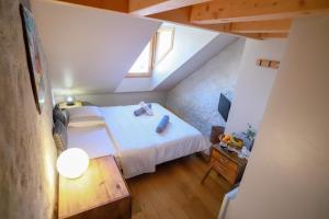 a small attic bedroom with a bed and a table at Nid douillet in Annecy