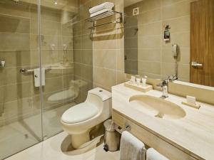 a bathroom with a toilet and a sink and a shower at Estelar Apartamentos Bellavista in Lima +29 photos