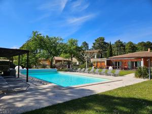 uma piscina com espreguiçadeiras e uma casa em Les Sables d'Ocre & SPA em Roussillon