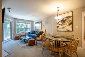 a living room with a table and a couch at True Ski in Ski out Condo with hot tub and pool at the Aspens in Whistler