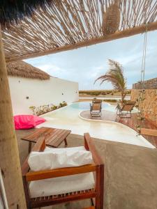 a patio with a table and chairs and a swimming pool at Villakite luxury in Itarema