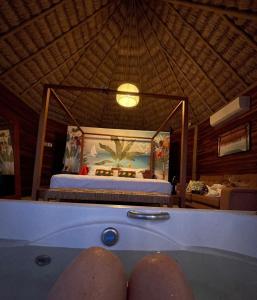a person taking a bath in a tub with a bed at Villakite luxury in Itarema