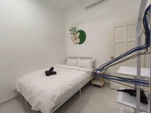 Un dormitorio blanco con una cama con zapatos. en PlayHouse Fun4Kids 22pax 6R5B, en Melaka