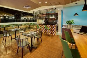 a restaurant with tables and chairs and a bar at Estelar Apartamentos Bellavista in Lima
