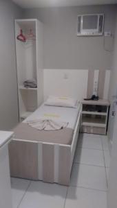 a hospital room with two beds and a microwave at Hotel Estação in Barueri