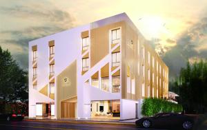 丹吉尔DIAGONAL HOTEL的一座白色的大建筑,前面有一辆汽车