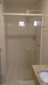 a bathroom with a glass shower with a sink at Hotel Estação in Barueri