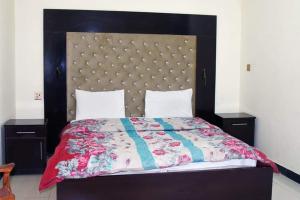 - une chambre avec un grand lit et une grande tête de lit dans l'établissement Abbotabad view hotal, à Abbottabad
