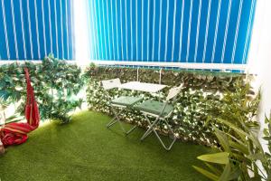 a patio with a table and chairs and plants at ELEVANA in Fuengirola