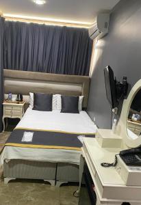 a bedroom with a bed with a desk and a monitor at Florya House Hotel in Istanbul