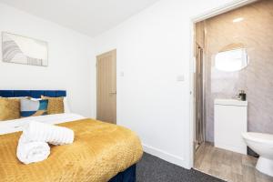 a bedroom with a bed and a sink and a toilet at 4 beds home, 3 baths, sleeps 8, free parking, contractors, trades in Purfleet