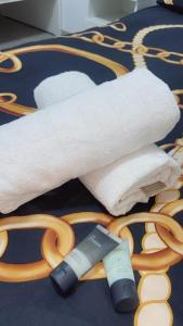 un groupe de serviettes blanches et une paire de ciseaux dans l'établissement Romy suites Deluxe, à Netanya