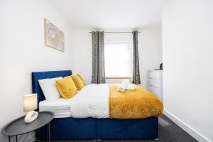 a bedroom with a blue bed and a window at 4 beds home, 3 baths, sleeps 8, free parking, contractors, trades in Purfleet