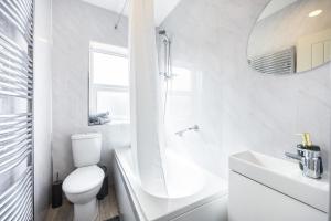 a white bathroom with a toilet and a sink at 4 beds home, 3 baths, sleeps 8, free parking, contractors, trades in Purfleet
