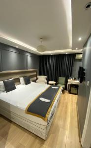 a bedroom with a large bed and a desk at Florya House Hotel in Istanbul