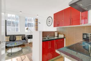 une cuisine avec des placards rouges et une table dans l'établissement Stylish Studio 3 - City Centre Coach Station, à Birmingham