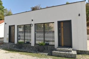een wit gebouw met glazen deuren en potplanten bij Villa Castella in Skopje