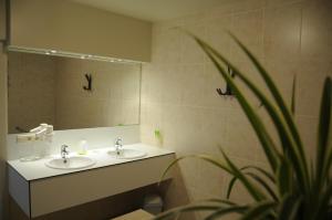 a bathroom with two sinks and a large mirror at Kapelhoeve in De Haan