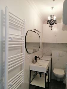 a white bathroom with a sink and a mirror at Ferienwohnung mit traumhaften Meerblick in Großenbrode