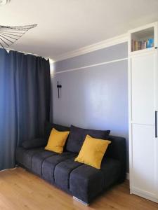 a blue couch with two yellow pillows in a room at Ferienwohnung mit traumhaften Meerblick in Großenbrode
