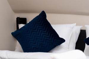 a blue pillow sitting on top of a white bed at Plac Kościuszki Modern Apartment in Wrocław