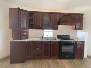 a kitchen with wooden cabinets and a stove top oven at GR20acd Mary in Cuauhtémoc