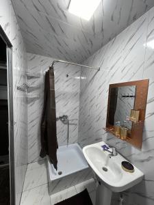 a white bathroom with a sink and a mirror at Hotel Zuxritdin with XIX century museum in Bukhara