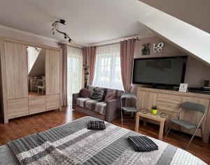 ein Wohnzimmer mit Bett und Flachbildfernseher in der Unterkunft Kanarek in Ustka