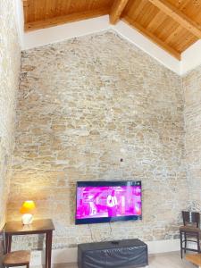 salon z telewizorem na kamiennej ścianie w obiekcie Medulin Labirint King w Medulinie