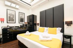 una camera da letto con un grande letto con asciugamani gialli e bianchi di Strozzi Palace Suites by Mansley a Cheltenham