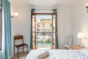 een slaapkamer met een bed en een raam met uitzicht bij Raisin- appartement familial donnant sur la Sorgue in LʼIsle-sur-la-Sorgue