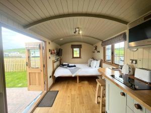 a bedroom with a bed in a room with a kitchen at Poppy in Rhayader