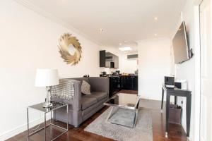 a living room with a couch and a table at Strozzi Palace Suites by Mansley in Cheltenham