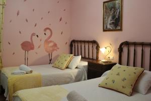 um quarto com 2 camas com flamingos na parede em La Cuadra I em La Pola de Gordón