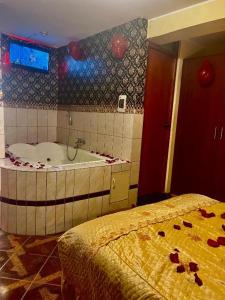 a bathroom with a tub and a bed at HOTEL ARC&SUITE in Tacna