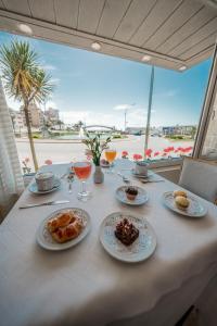 una mesa con platos de comida y bebidas. en Hotel Iruña en Mar del Plata