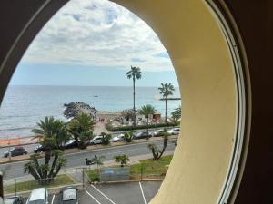uma vista para o oceano a partir de uma janela em Appartamento-Oblò sul Mare em Sanremo