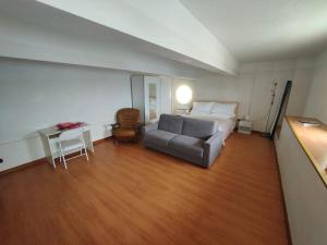 um quarto com uma cama, uma mesa e um sofá em Appartamento-Oblò sul Mare em Sanremo