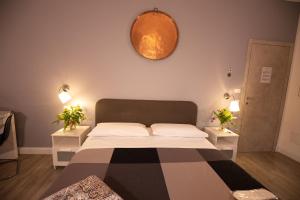 a bed in a room with two tables and a mirror at Bru Rooms in Peschiera del Garda