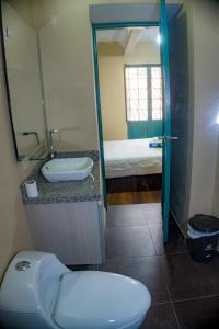 La salle de bains est pourvue de toilettes, d'un lavabo et d'un lit. dans l'établissement By Cao Rest House, à Bogotá