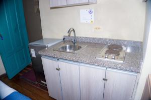 Elle comprend une petite cuisine équipée d'un évier et d'un réfrigérateur. dans l'établissement By Cao Rest House, à Bogotá