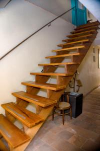 a staircase in a building with wooden steps and a chair at By Cao Rest House in Bogotá