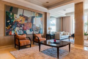 a living room with a table and a painting at Hotel Iruña in Mar del Plata