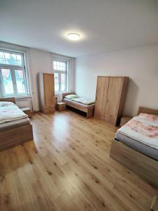 three beds in a room with wooden floors and windows at Monteurwohnungen am Hauptplatz 1 in Amstetten