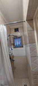 a bathroom with a shower with a window in it at Home sweet home in Kigali