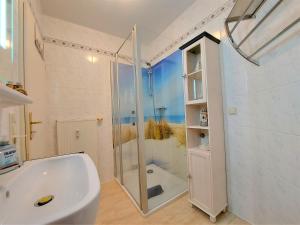 a white bathroom with a shower and a sink at Komfortferienwohnung Kreideblick in Sassnitz