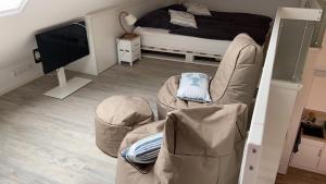 a bedroom with a bed and two chairs and a television at Moderne Ferienwohnung Meerestraum in Dangast in Varel